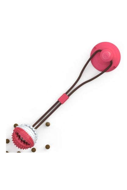 "Dog playing with interactive chewable toy featuring food dispensing compartment"